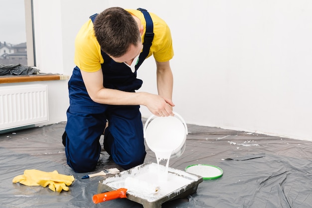 The man paints the walls and the ceiling in white color\
painting and repair of the room.