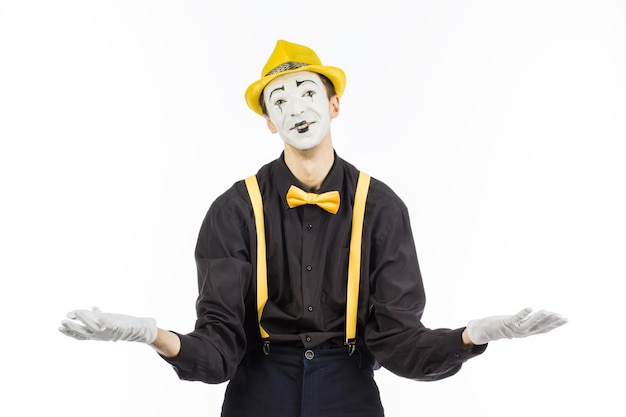 Мужчина пантомимный актер с широко расставленными руками улыбается на белом фоне