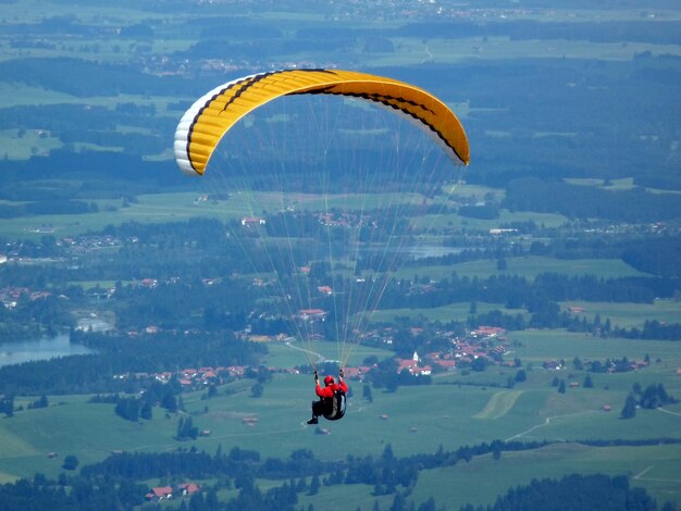 Foto man parapenteert over het landschap