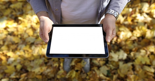 Uomo nel pc digitale della compressa della tenuta del parco con lo schermo in bianco