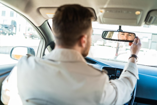 Man past de spiegel in de auto aan