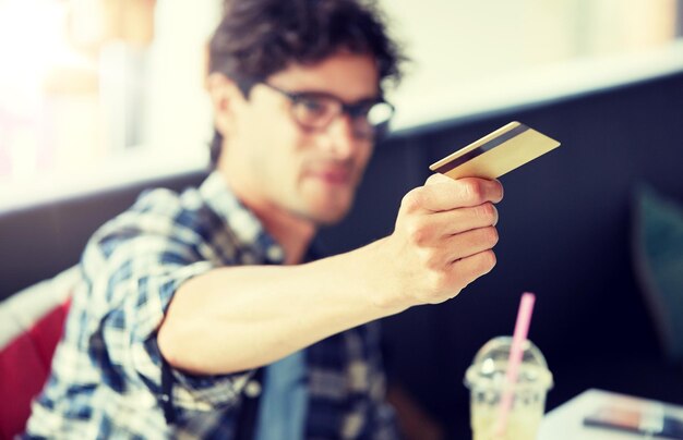 Photo man paying with credit card at cafe