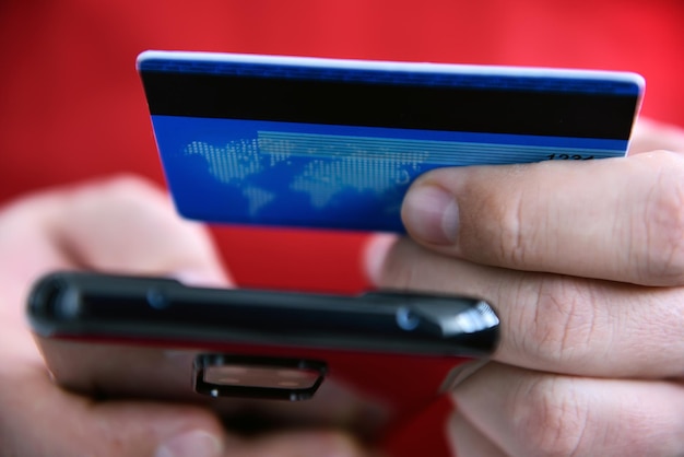 Фото Мужчина платит кредитной картой онлайн, делая заказы через интернет с мобильного телефона