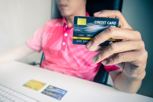 Man paying with credit cards on computer at home