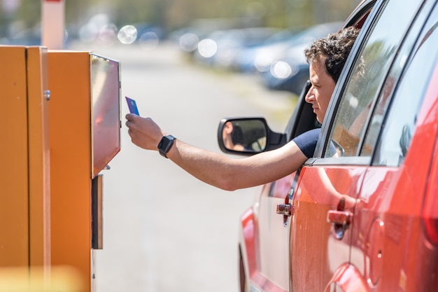 Foto l'uomo paga parcheggiando la carta di credito nel parchimetro