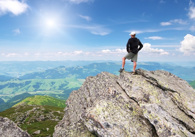 Photo man on peak of mountain.