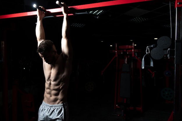 Man Performing Hanging Leg Raises Exercise For Abs