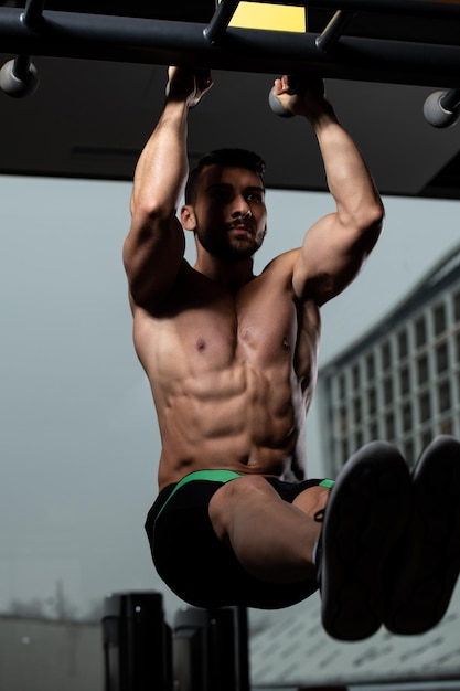 Man Performing Hanging Leg Raises Exercise