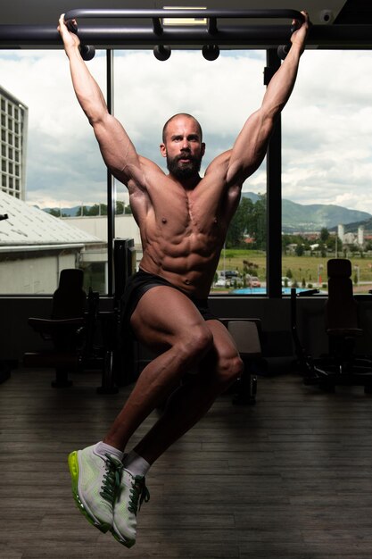 Man Performing Hanging Leg Raises Exercise