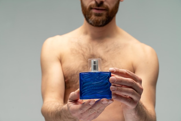 Man perfume fragrance Perfume or cologne bottle and perfumery cosmetics scent cologne bottle male holding cologne Masculine perfume bearded man