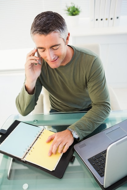 Man on the phone checking his notes