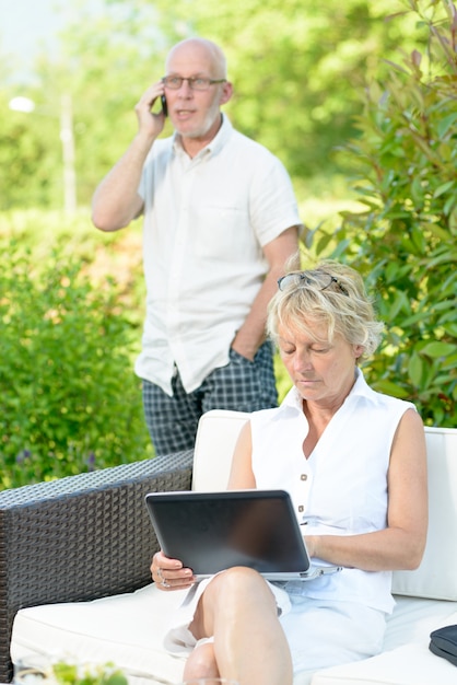 A man on phone and his wife on  computer