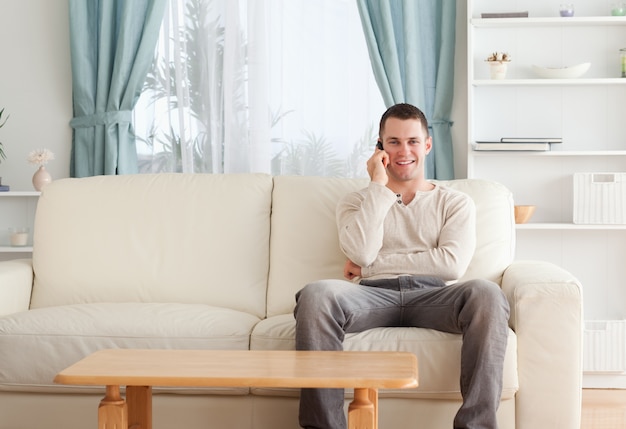 Man on the phone while sitting on his couch