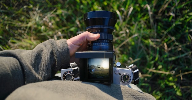 Man photographer is making landscape photography with old film camera in spring or summer tourism and hiking concept top view copy space