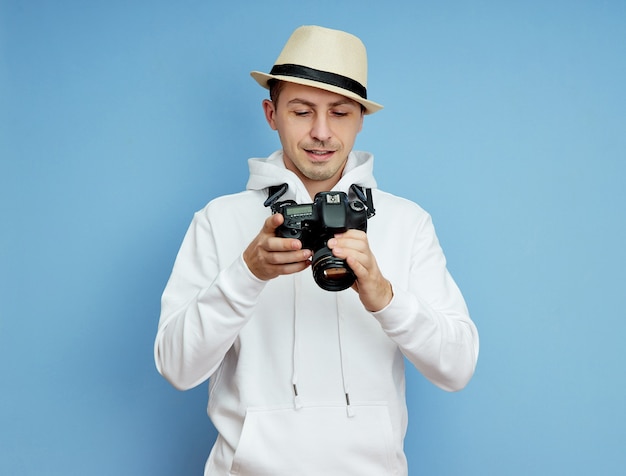 Il fotografo dell'uomo con una fotocamera reflex tra le mani scatta foto