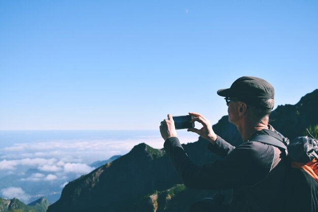 写真 空に照らして写真を撮る男