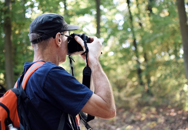 写真 森で写真を撮っている男