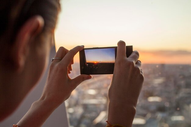 写真 空に向かってスマートフォンで写真を撮っている男性