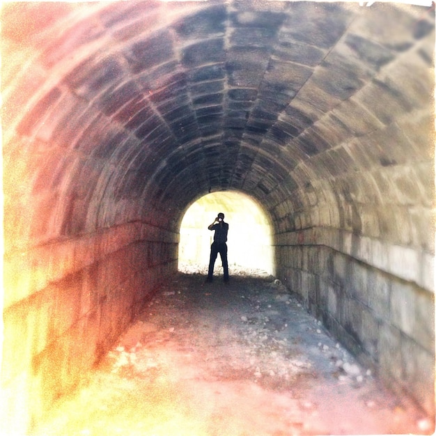 Foto uomo che fotografa nel tunnel.