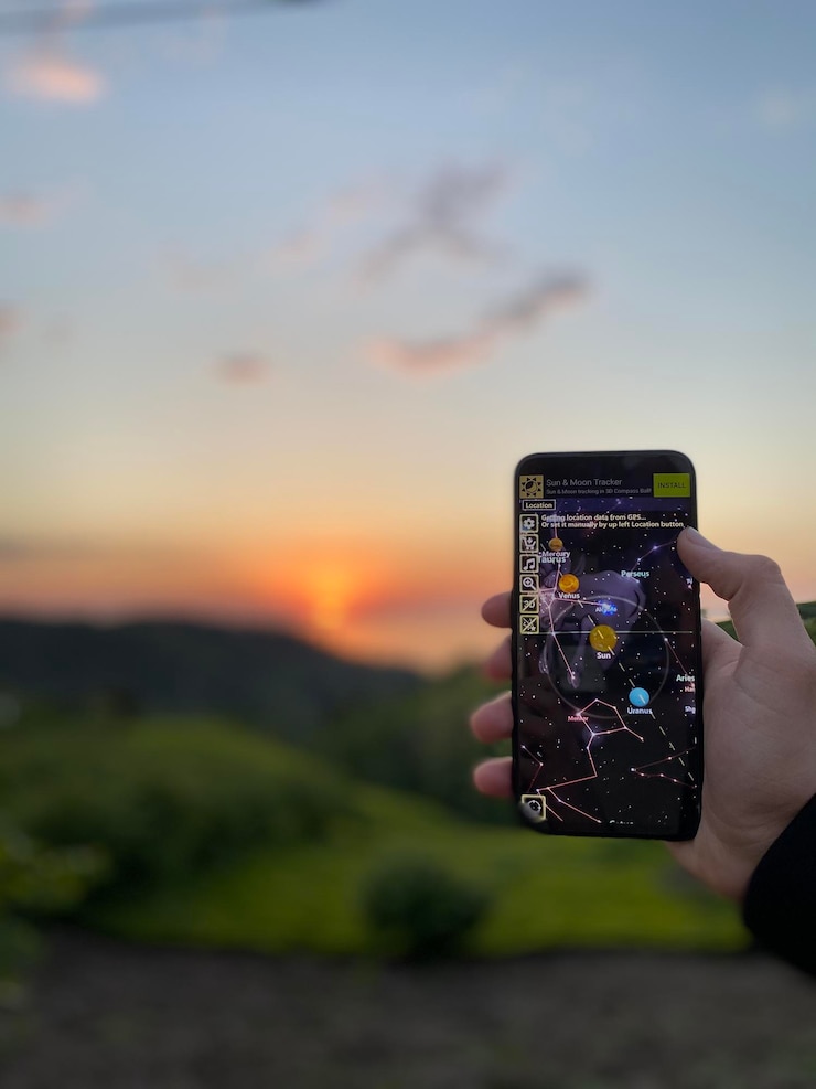 Фотография человек фотографирует с помощью смартфона на небе во время захода солнца