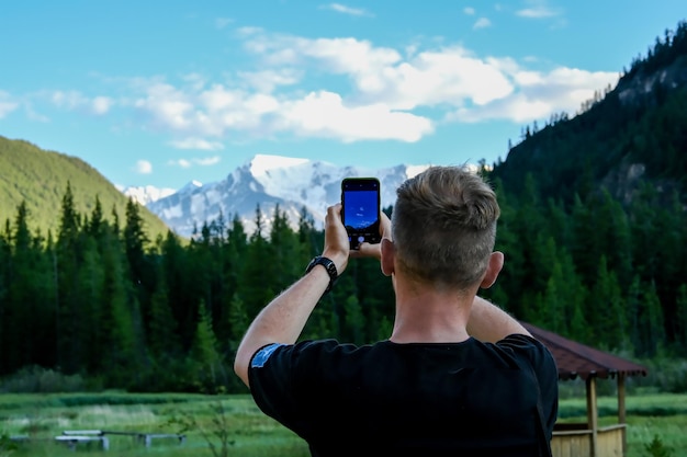 한 남자가 산을 찍는다 한 관광객이 알타이의 풍경을 찍는다 한 관광객이 숲을 찍는다 한 관광객이 알타이 알타이 산맥의 광경을 찍는다