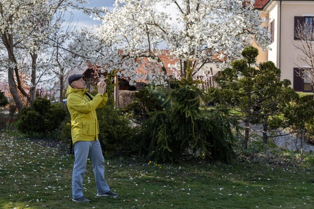 A man photographs a spring park on a smartphone