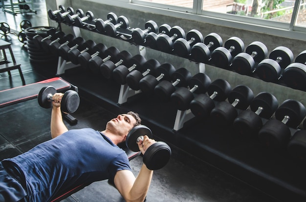 Man pickup dumbell in gym . exercise with work out program for healthy