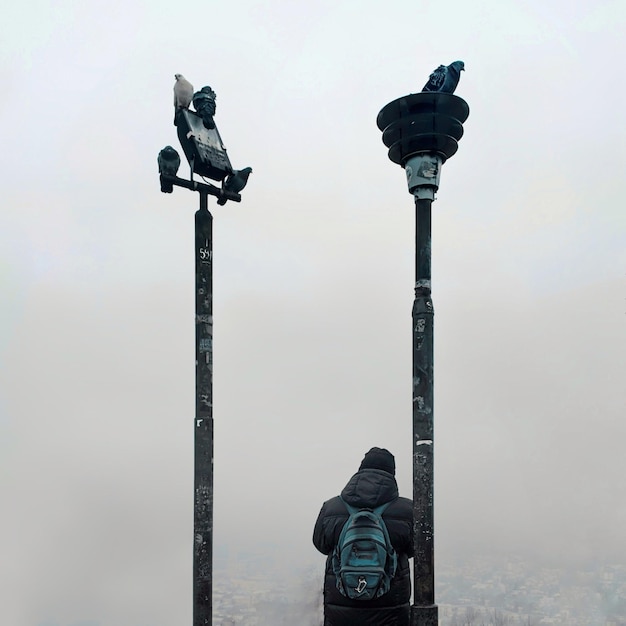 Man and pigeon on a pole