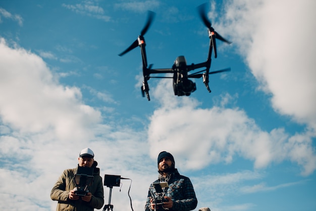 Man piloot besturen van quadcopter drone met afstandsbediening pad.