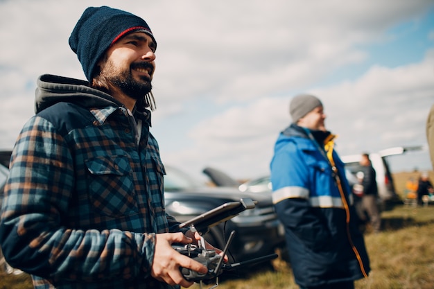 Man pilot controlling quadcopter drone with remote controller pad