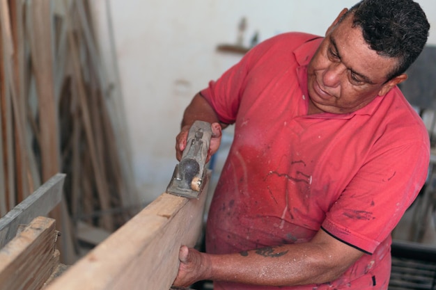 Man places finishing details on piece of furniture