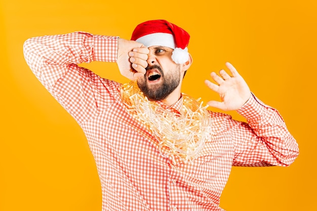 A man in a plaid pink shirt with a Christmas garland around his neck stretches