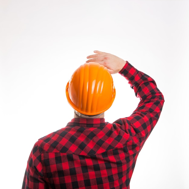 Мужчина в клетчатой рубашке и строительном шлеме сзади, вид сзади изолирован