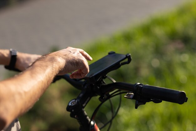 Man planning route using GPS navigation application in mobile phone on his bicycle bike.