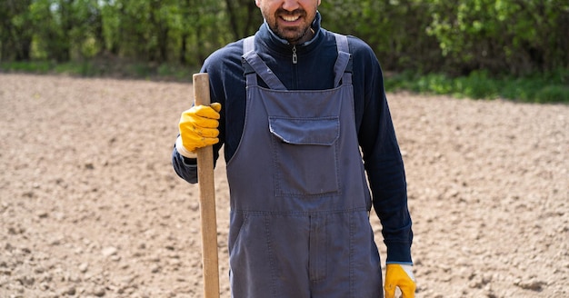 A man planting potatoes in the ground in early spring Farmer with a shovel