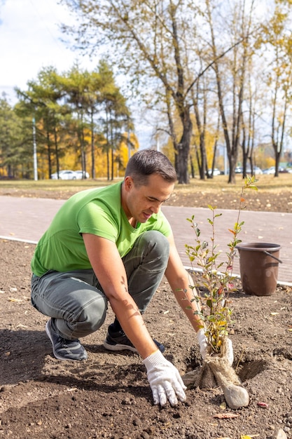 A man plants a tree in the city Landscaping Ecology