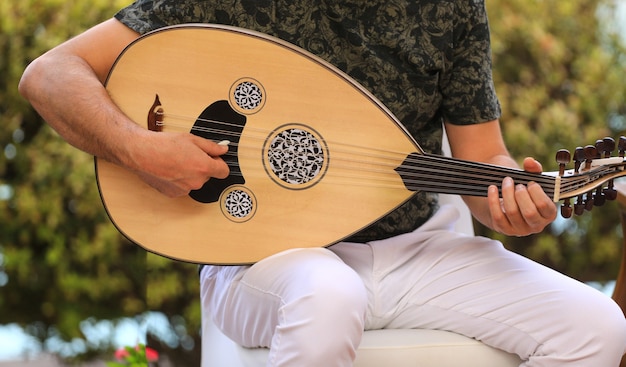 Foto un uomo che suona uno strumento musicale arabo