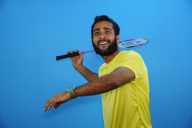 Man playing badminton isolated on blue background