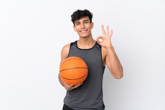 Uomo che gioca a basket sopra la parete isolata