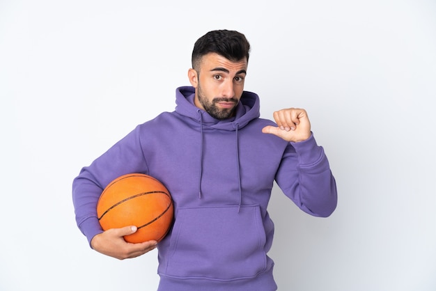 Man playing basketball over isolated white wall proud and self-satisfied