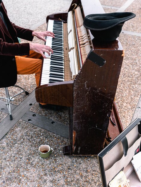 Foto uomo che suona il pianoforte marrone all'aperto foto