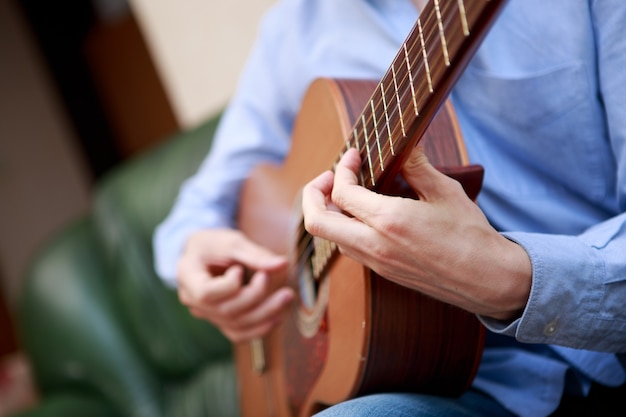 Uomo che suona la chitarra acustica classica