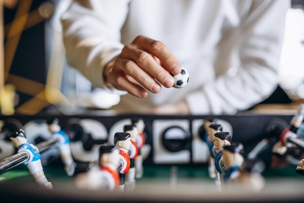 Uomo che gioca partita di calcio sul calcio balilla