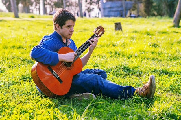 Photo man playing guitar on field