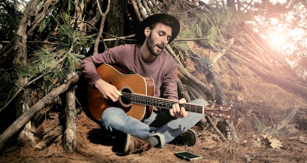Man playing guitar in forest
