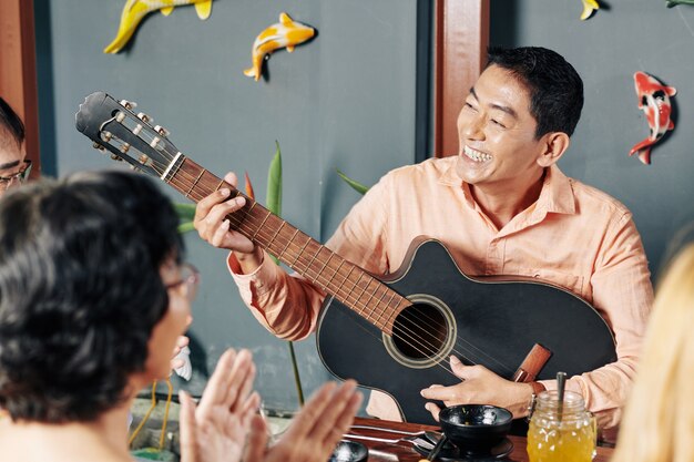 Man playing guitar fro friends and relatives