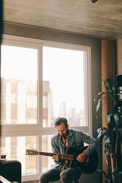 Photo man playing guitar at home