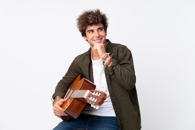 Man playing guitar over isolated wall