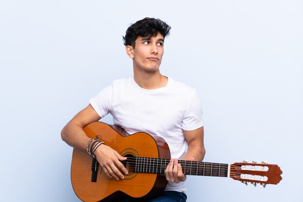 Man playing guitar over isolated wall