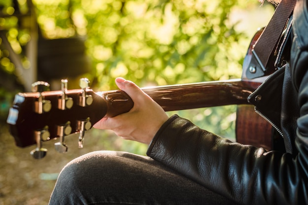 Uomo che suona la chitarra in natura in una giornata di sole